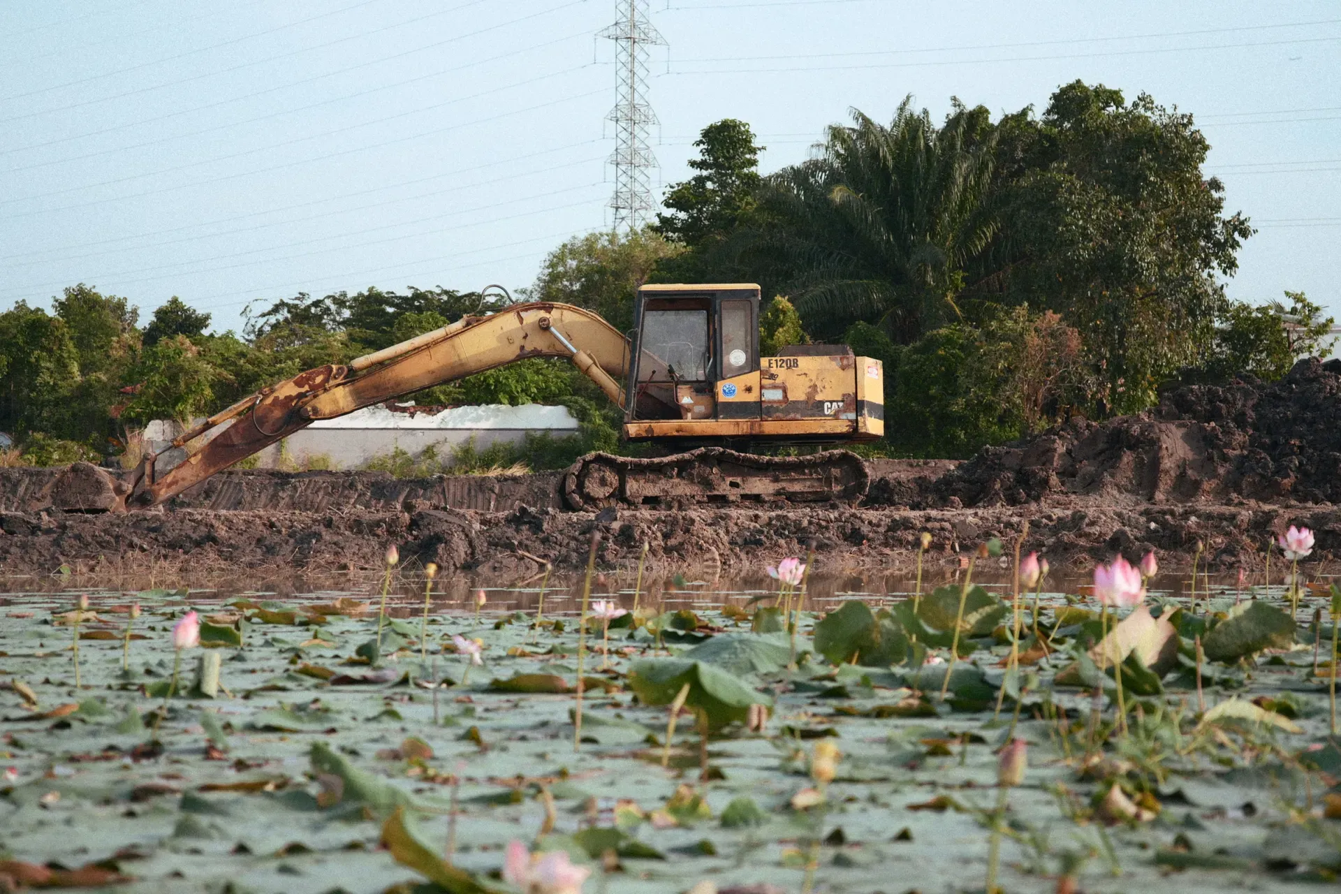 Excavator shaping a pond basin, illustrative of the pond building work the contractor performs
